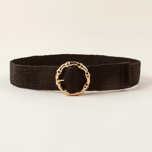 Close-up of black woven belt featuring a golden round bamboo-style metal buckle detail