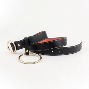 Détail de la ceinture en cuir noir avec coutures blanches et anneau en métal doré