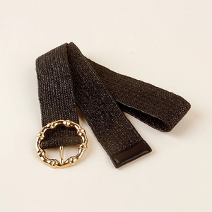 Detail of black woven elastic belt featuring a vintage gold bamboo-textured round buckle