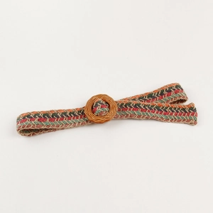 Detail of bohemian hand-woven belt with colorful fiber patterns and a round resin buckle