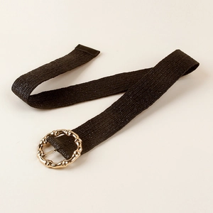 Close-up of black braided belt with a textured gold-tone circular bamboo style buckle