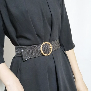 Bohemian black woven elastic waist belt with a gold round bamboo-style buckle