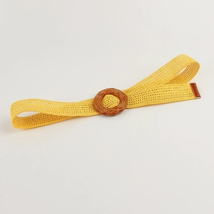 Detailed view of the ginger yellow woven waist belt with a round wood-style buckle