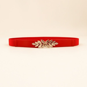 Détail de la ceinture élastique rouge avec boucle décorative en feuille dorée