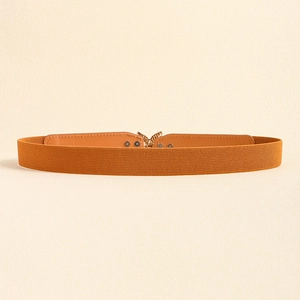Vue détaillée de la ceinture élastique jaune gingembre avec boucle papillon en métal doré