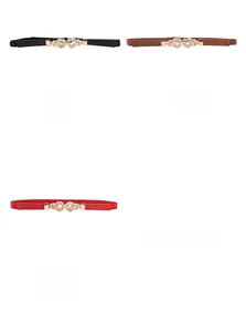 Detailed view of elastic waist belts in black, brown, and red with gold twist buckles