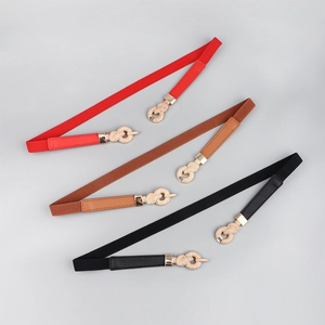 Close-up of thin elastic waist belts in red, brown and black with gold knot buckles