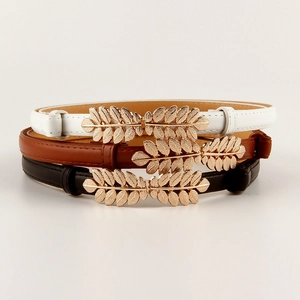 Close-up of three elastic belts in black brown white with golden leaf buckles