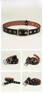 Close-up of black punk belt featuring polished gold metal grommets and a pin buckle