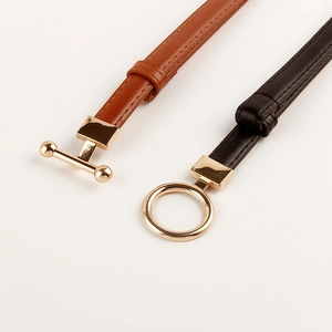 Detail of slim black and brown leather belts with elegant gold O-ring and T-bar buckles