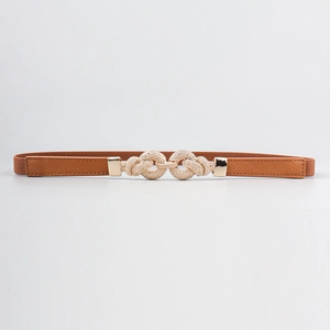Detail of thin brown elastic belt with golden interlocking knot buckle for dresses