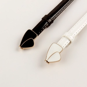 Detail of slim black and white waist belts with spade-shaped buckles and gold edges