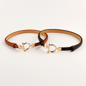 Close-up of slim leather belts with gold T-bar buckles in black and caramel brown colors