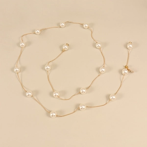 Détail de la chaîne de taille perlée dorée avec fermoir mousqueton pour robe femme