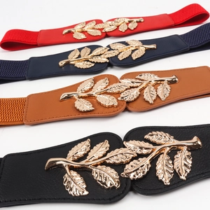 Detail of elastic waist belts in four colors featuring golden leaf-shaped metal buckles