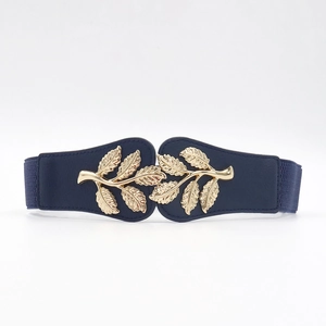 Close-up of golden leaf buckle on navy elastic waist belt with metallic texture