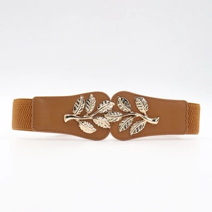 Close-up of golden leaf metal buckle on brown elastic waist belt for dresses