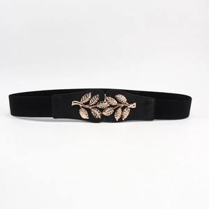 Close-up of golden leaf-shaped metal buckle on black elastic waist belt for women
