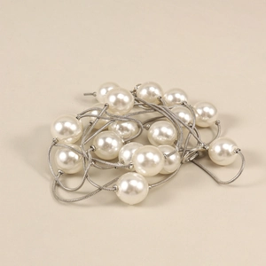 Détail de perles blanches sur une ceinture chaîne serpent argentée pour robes femme