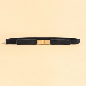 Detail of black elastic belt with golden rectangular mirror-polished buckle for dresses