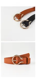 Detailed view of fashionable leather belts with golden horseshoe buckles in black and brown
