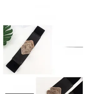 Macro shot of bronze vintage buckle on wide elastic corset belt with floral patterns