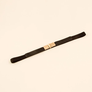 Detail view of a black elastic waist belt with a square gold metal buckle on a plain background