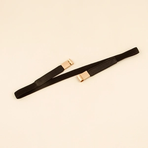 Detail of slim black elastic waist belt featuring a gold metal buckle for dresses