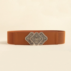 Detail of vintage metal diamond buckle with intricate patterns on a wide brown belt