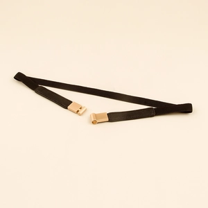 Detail of golden square buckle on black elastic waist belt for women vintage style