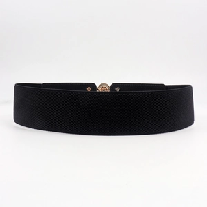 Detail of vintage gold floral buckle on a black wide elastic belt for dresses