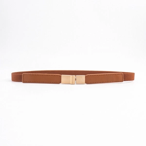 Detail view of caramel brown elastic waist belt with gold rectangular metal buckle closure