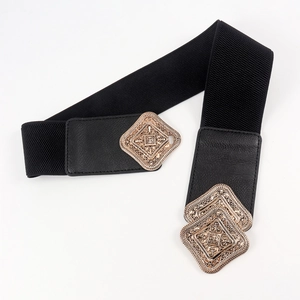 Detail of vintage gold baroque buckle on a wide black elastic waistband for dresses