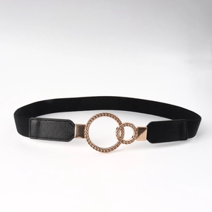 Detail of black elastic belt featuring interlocking gold circular metal rings and faux leather