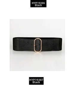 Detail of wide black elastic belt with gold oval buckle and lychee grain texture