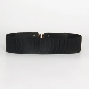 Detail of black elastic waist belt with gold square buckle and leather finish