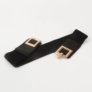 Detail of black elastic waist belt with large polished gold square metal buckle