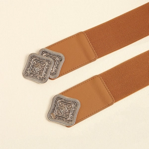 Detail of vintage silver metal buckle on brown elastic waist belt with engraved patterns