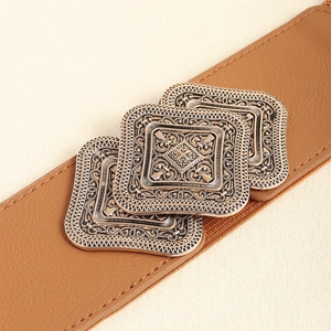 Detailed view of vintage bronze embossed metal buckles on a brown leather waist belt