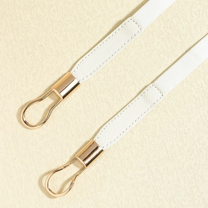 Detail of white elastic waist belt featuring premium gold double ring metal buckles