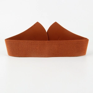 Detail of brown wide elastic waist belt with symmetric leather patches and neat stitching