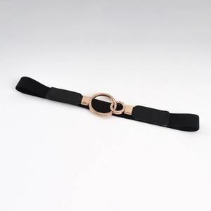Detail of interlocking rose gold circles on a black elastic belt for women dresses