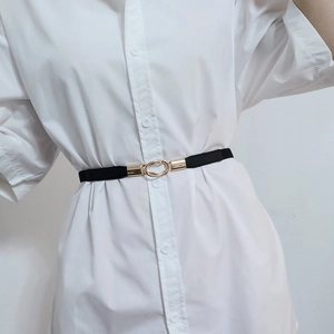 Detailed view of a slim black elastic waist belt with a golden double ring buckle on a shirt