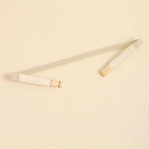 Detail of beige elastic waist belt featuring a polished gold square buckle closure