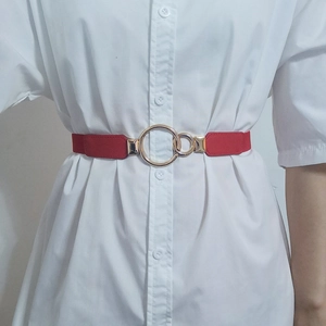 Close-up of bright red elastic waist belt with gold double interlocking metal rings