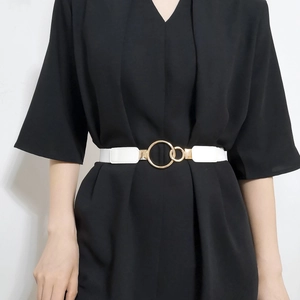 Detail of white elastic waist belt with elegant gold double ring buckle on a model