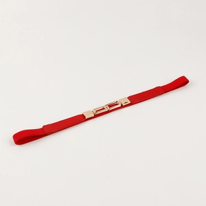 Detail of red elastic waist belt featuring a polished gold rectangular metal buckle