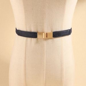 Detailed macro view of dark blue waist belt with gold rectangular buckle and litchi texture