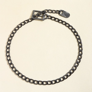 Detail of gunmetal thick chain with a punk square buckle and oval decorative plate