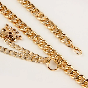 Detail of gold layered waist chain featuring thick curbs and elephant pendant charm